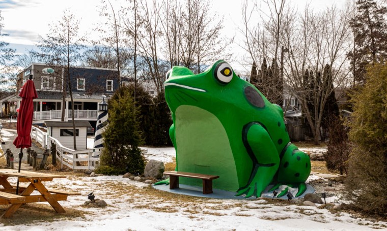A large, green statue of a frog, known as The Fontana Frog